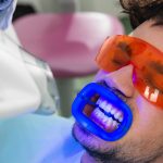 male teeth whitening patient getting in office light-activated treatment