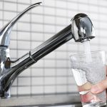 filling a glass of water from kitchen faucet